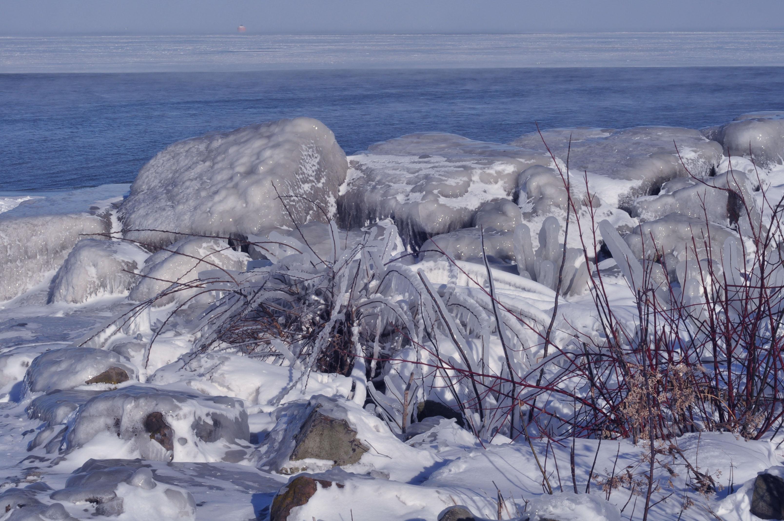 Snow and ice covered rocks on the Lake Erie shoreline.